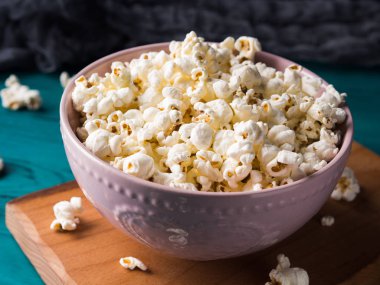 Koyu arka plan üzerinde pembe kase patlamış mısır