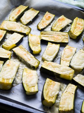 Otlar ve parşömen pişirme üzerinde peynirli kabak yarım pişmiş