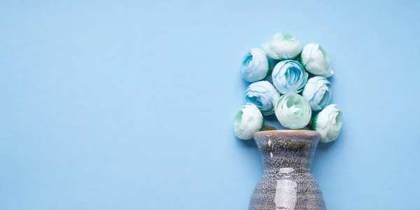 Florero con flores decorativas sobre fondo azul — Foto de Stock