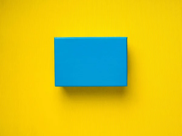 Niebieskie pudełko na żółtym tle — Zdjęcie stockowe