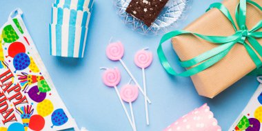 Mutlu Doğum günü partisi öğeleri düz yatıyordu. Mumlar, hediye kutusu, dekorasyon afiş, kağıt bardak, çikolatalı kek