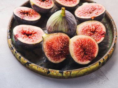 Yeşil bir tabak üzerinde mor taze incir