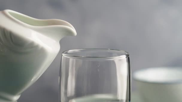 Milch aus einem Krug in ein Glas gießen — Stockvideo