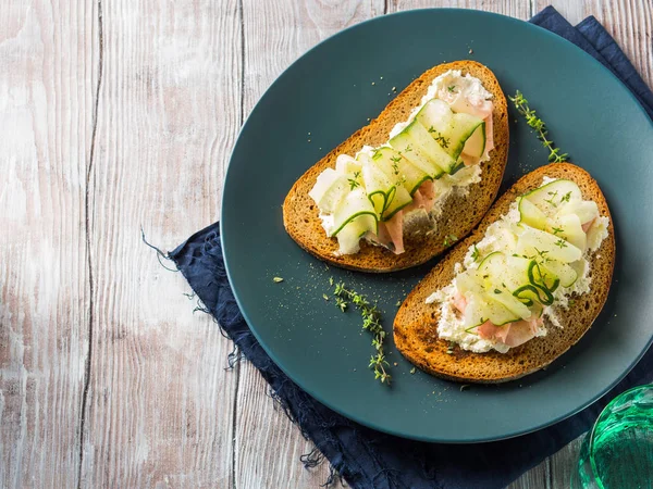 Rye bread toasts with cheese, ham, cucumber