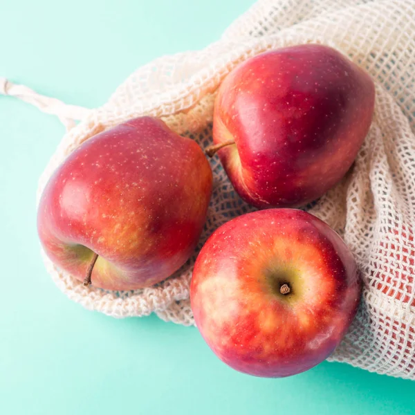 Красные яблоки в многоразовых хлопковых мешках — стоковое фото
