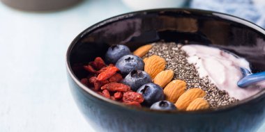 Meyveler, fındık, chia ile güler yüzlü kase yoğurt