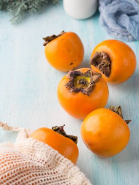 Olgun hurma turkuaz arka plan üzerinde. Sonbahar kış meyve