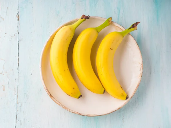 Banány v misce na pastelově zelená — Stock fotografie