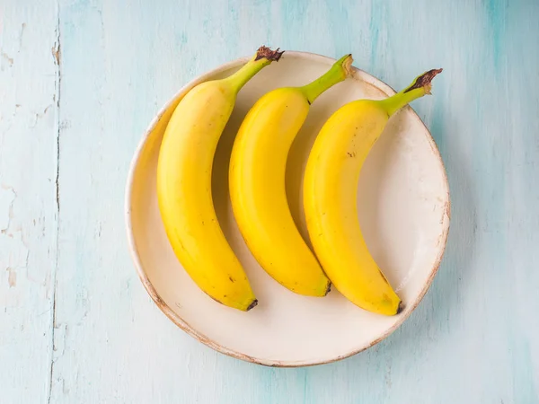 Bananas em um prato em fundo pastel verde — Fotografia de Stock