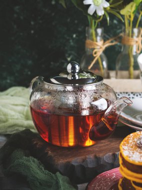 Sıcak çay yeşil arka plan üzerinde cam çaydanlık