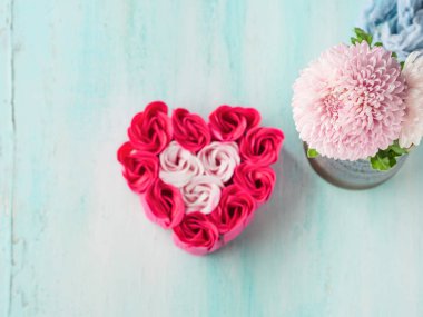 Pembe kırmızı gül pastel renk üzerinde kalp şeklinde