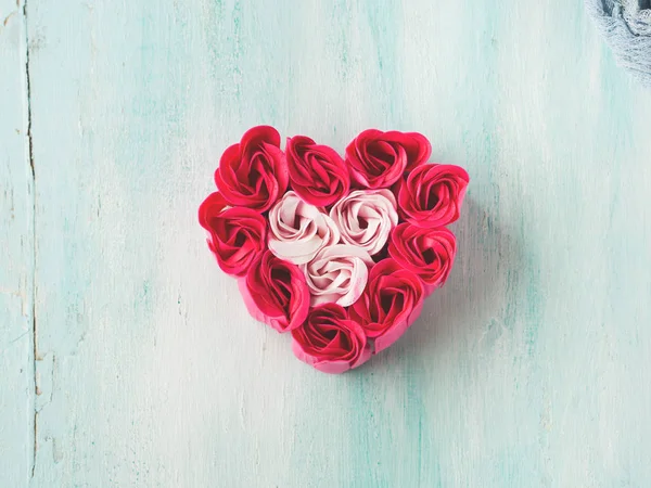 Рожеві червоні троянди у формі серця на пастельному кольорі — стокове фото