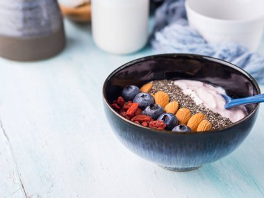 Meyveler, fındık, chia ile güler yüzlü kase yoğurt