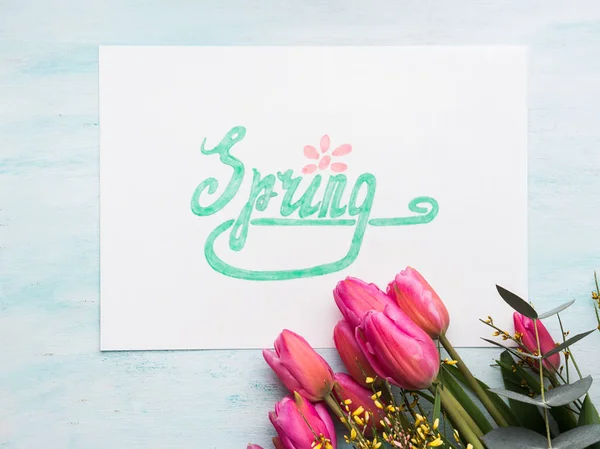 Schöne Tulpen und Wortfrühling in grünen Buchstaben — Stockfoto