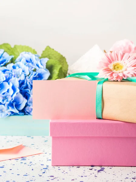 Чистая розовая карта и упакованные подарочные коробки. Цветы — стоковое фото