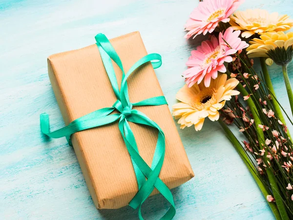 美丽的花朵和礼品盒上柔和的绿色 — 图库照片