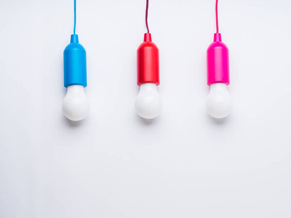 Color light bulb lamps on white. Concept