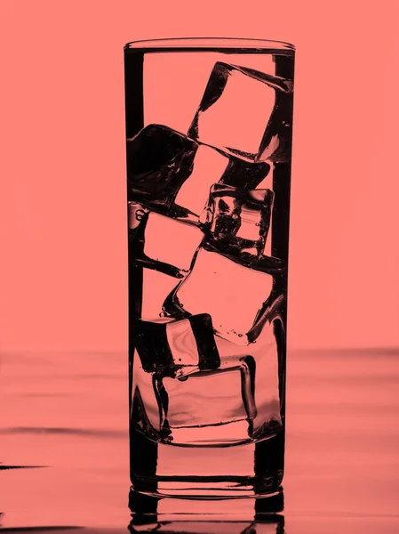 Glas water met ijsblokjes. Koraal toned — Stockfoto