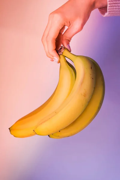 Un mucchio di banane nelle mani delle donne. Colori al neon — Foto Stock