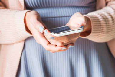 Beyaz smartphone kullanan kadın. Pastel renkler