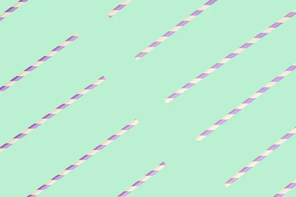 Purple paper straws on mint green background