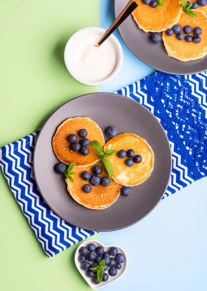 Pancakes served with blueberries on gray plate — Stock Photo, Image