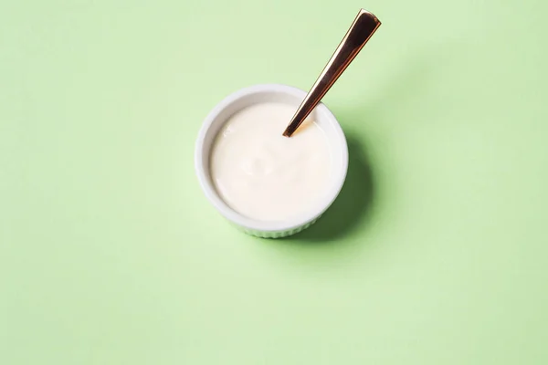Cuenco de yogur natural sobre verde pastel — Foto de Stock