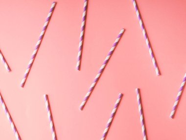 Pembe renkli arka planda mor kağıt pipetler