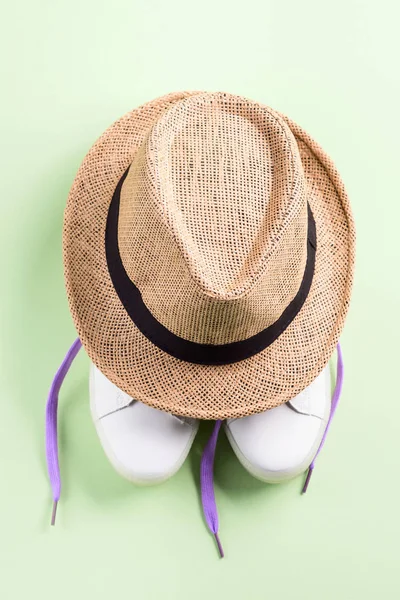 White sneakers with purple laces and straw hat