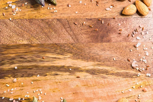 Dark wooden chopping board with nuts, seeds frame — Stock Photo, Image