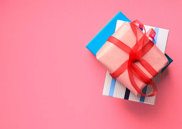 Geschenkboxen stapeln sich auf rosa Korallen Hintergrund — Stockfoto