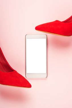 Kırmızı yüksek topuklu ayakkabılar ve akıllı telefon ekranı