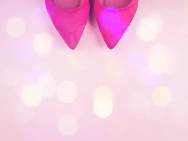 Pink background with womans pumps and festive lights — Stock Photo, Image