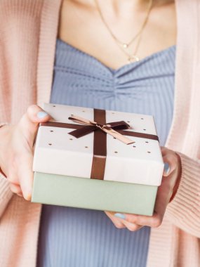 Elinde fiyonklu bir hediye kutusu olan kadın. Pastel