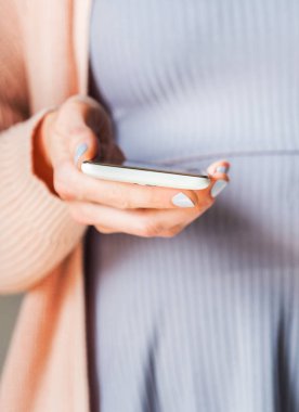 Beyaz smartphone kullanan kadın. Pastel renkler