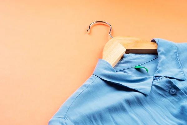 Camisa de mujer azul en percha en naranja — Foto de Stock