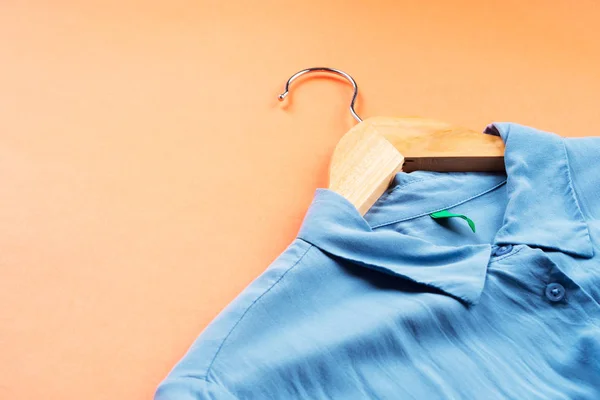 Camisa de mulher azul em cabide em laranja — Fotografia de Stock