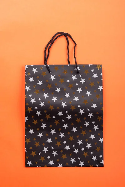 Black gift bag with stars on orange coral