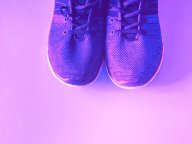 Tek renkli arka planda mor eğitmenler.