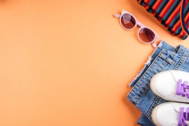 Moda düz kot ve portakal üzerinde gözlük ile yatıyordu