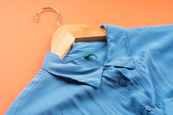 Camisa de mulher azul em cabide em laranja — Fotografia de Stock