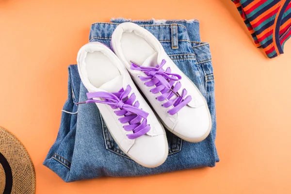 Fashion flat lay with jeans and glasses on orange