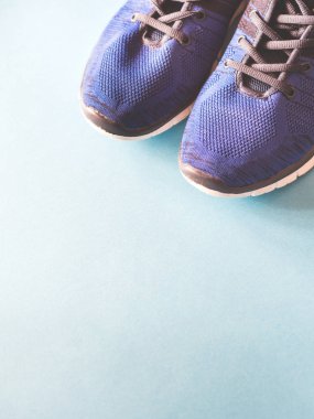 Tek renkli arka planda mavi spor ayakkabılar.