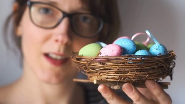 Pretty woman with Easter eggs in nest. Greetings — Stock Video