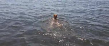 Napoli'de siyah kum denizinde yüzen küçük çocuk