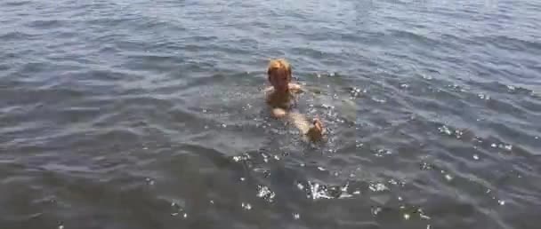 Kleine jongen zwemmen in zwarte zand zee in Napels — Stockvideo