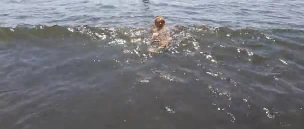 Мальчик плавает в черном песке в Неаполе — стоковое видео