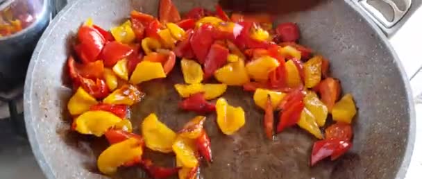 Stekning färgglada paprika i en stekpanna — Stockvideo