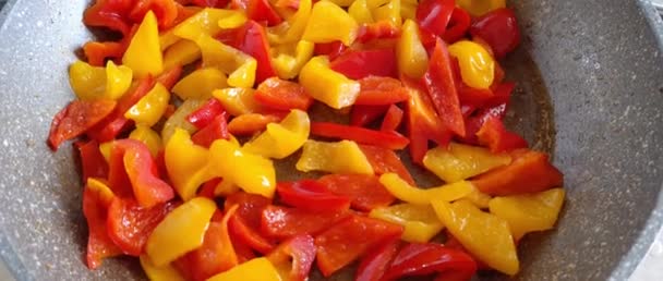 Frying colorful bell peppers in a skillet — Stock Video