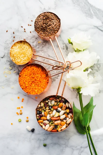 Copas de cobre con frijoles y cereales sobre mármol — Foto de Stock